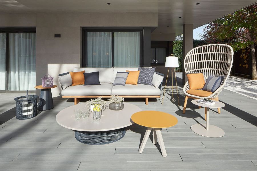 patio with white sofa, orange and blue cushions, white armchair and coffee table, orange side tables