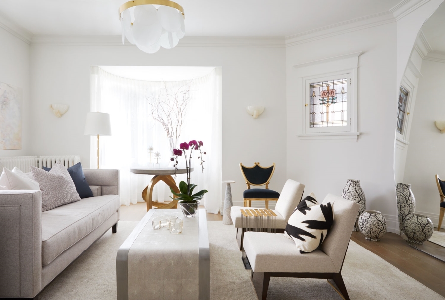 Dining And Living Room Inspirations By Elizabeth Metcalfe. This neutral living room has alight grey sofa, two white armchairs with wood structure, a white coffee table and a neutral rug.
