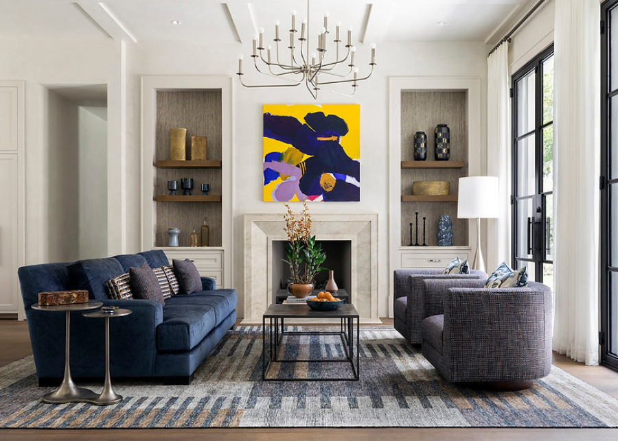 Benjamin Johnston Design: Dining And Living Room Inspiration. A living room decorated in blue and purple tones. There's a blue sofa, two purple-toned single sofas, a center table and a side table. The rug covers all the sofas area.